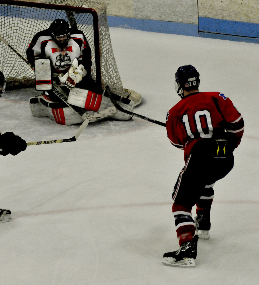 Winslow goalie Andrew Beals snares a shot off the stick of Messalonskee’s Brandon Nale during a Class B North game Wednesday at Sukee Arena.