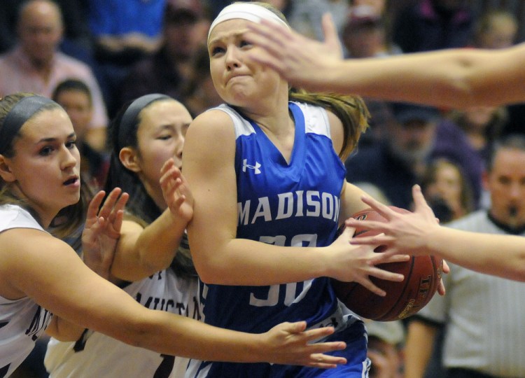 Madison’s Madeline Wood tries to push through a tough Monmouth defense during a Mountain Valley Conference game Tuesday night in Monmouth.