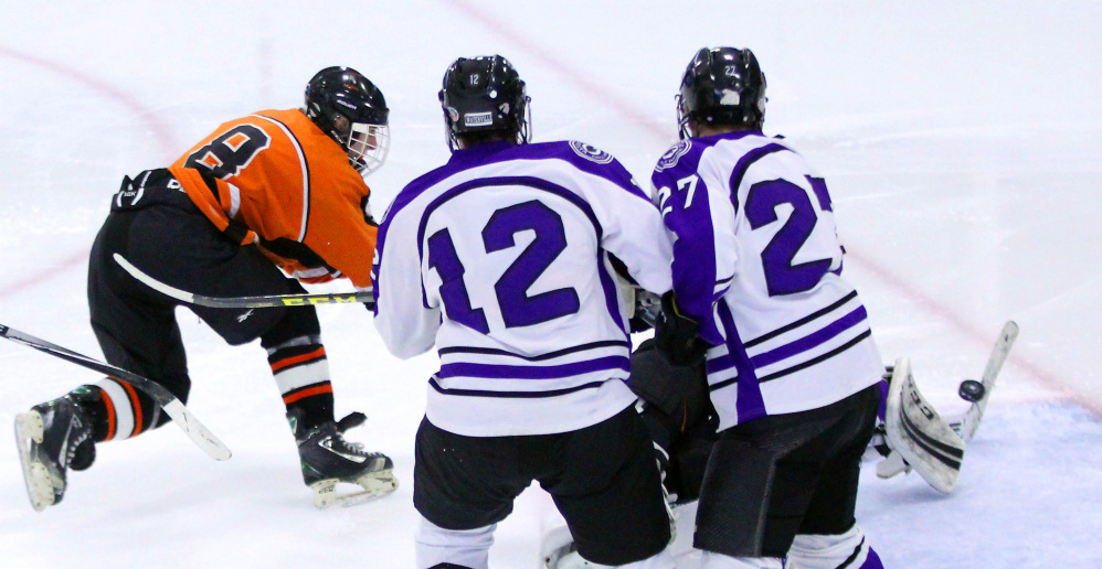 Winslow High School’s Tommy Tibbetts fires a shot past Waterville Senior High School goalie Nathan Pinnette as Zach Smith (12) and Chase Wheeler (27) look on during second-period action at Colby College in Waterville on Monday. The teams played to a 4-4 overtime tie.