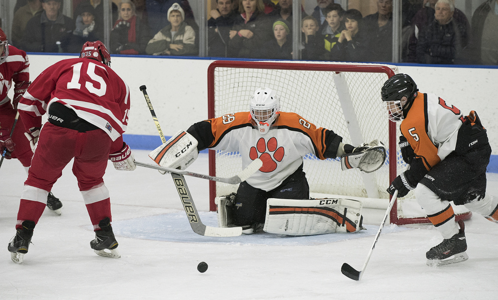 Gardiner’s Warren Karlberg, right, and goalie Michael Poirier defend against Cony’s Cole Lockhart on Saturday at the Ice Vault in Hallowell. Gardiner won 3-2.