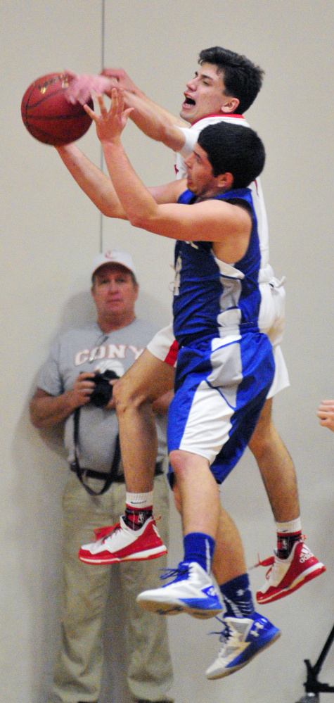 Cony’s Matt Murray, top, and Lawrence’s Kyle Robinson battle for a rebound during a game Saturday at Cony High in Augusta.