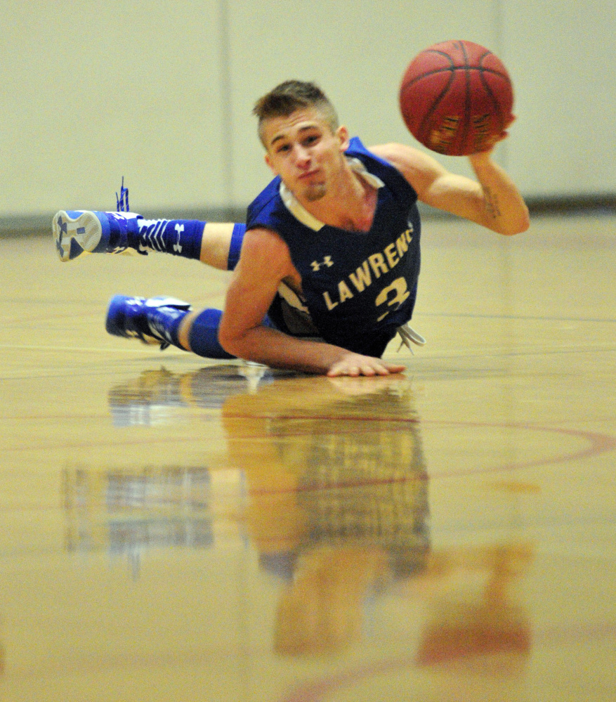 Lawrence’s Walker Thomas looks to pass after scrambling on the floor for a loose ball during a game against Cony on Saturday at Cony High in Augusta.