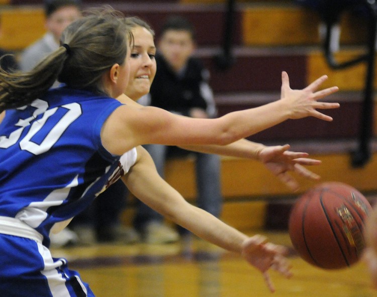 Richmond’s Autumn Acord, right, passes around Searsport’s Paige Ireland  during a Class C South game Monday night in Richmond.