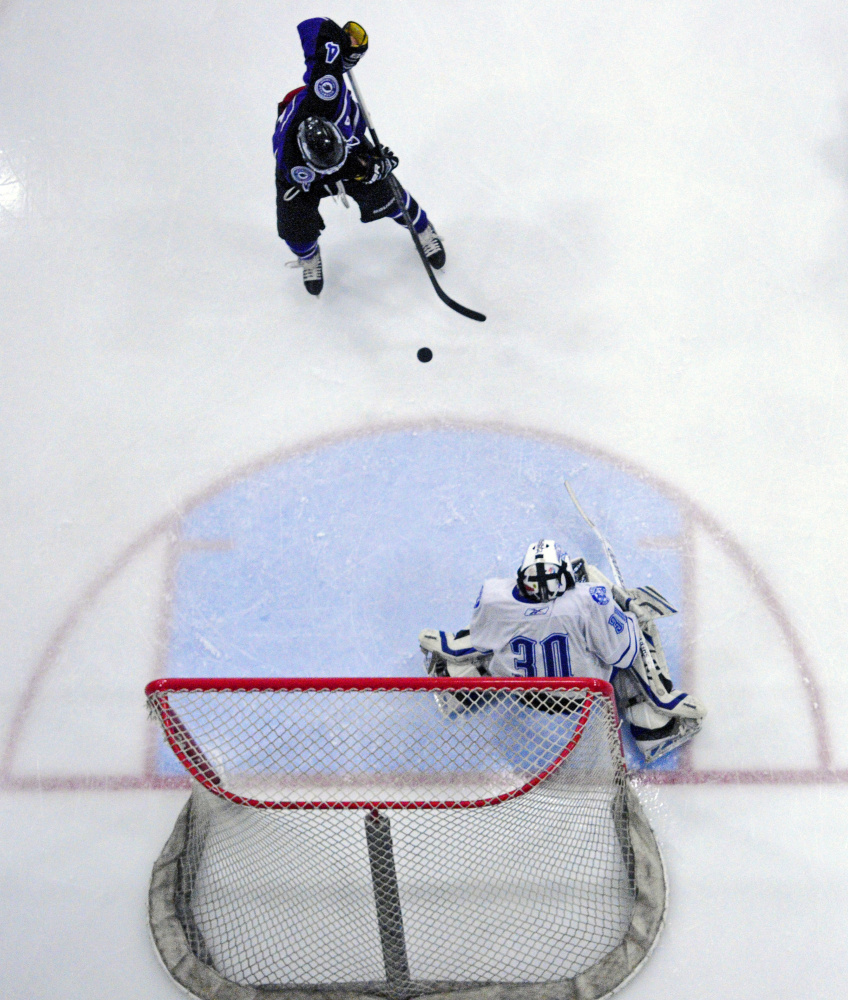 Waterville senior forward Michael Oliveira, top, lines up a shot as he scores a first period goal on Lewiston junior goalie Jacob Strout on Wednesday at Androscoggin Bank Colisée in Lewiston.