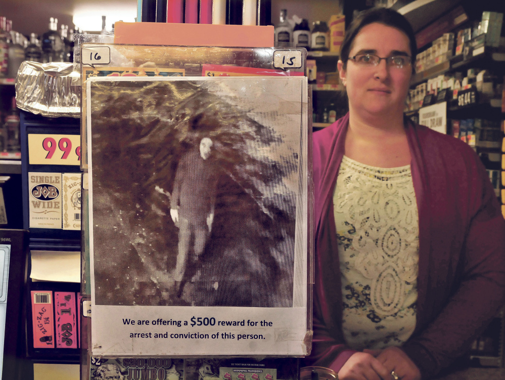 Kate Anton, manager of the Athens Corner Store, Jan. 19 holds up a poster she made of a surveillance camera image of someone who tried to break into the store the day before. Jims Variety in Athens was also burglarized that night. Two Hartlend men have been arrested in connection with the attempted break-in an burglary.