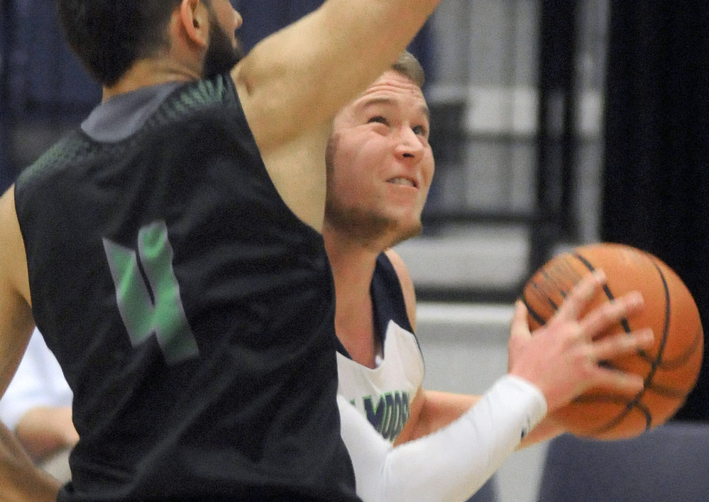 Staff photo by Andy Molloy 
 University of Maine at Augusta's Keith Chesley, right, goes for a shot around a University of Maine at Machias guard during a game Thursday in Augusta. Chesley scored his 2,000th career point during the matchup.