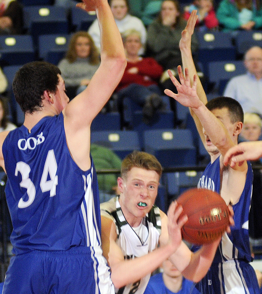 Staff photo by Andy Molloy
Winthrop High School’s Jacob Hickey, center, looks for an opening through Old Orchard Beach High School’s Sam Custeau, left, and Zach Hirst on Monday in Augusta.