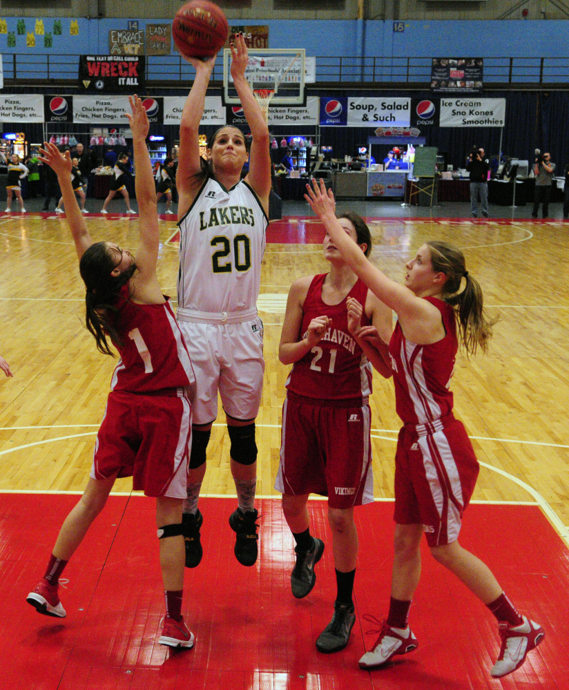 Rangeley’s Blayke Morin shoots over a group of Vinalhaven defenders during the Class D South championship game on Saturday at the Augusta Civic Center.