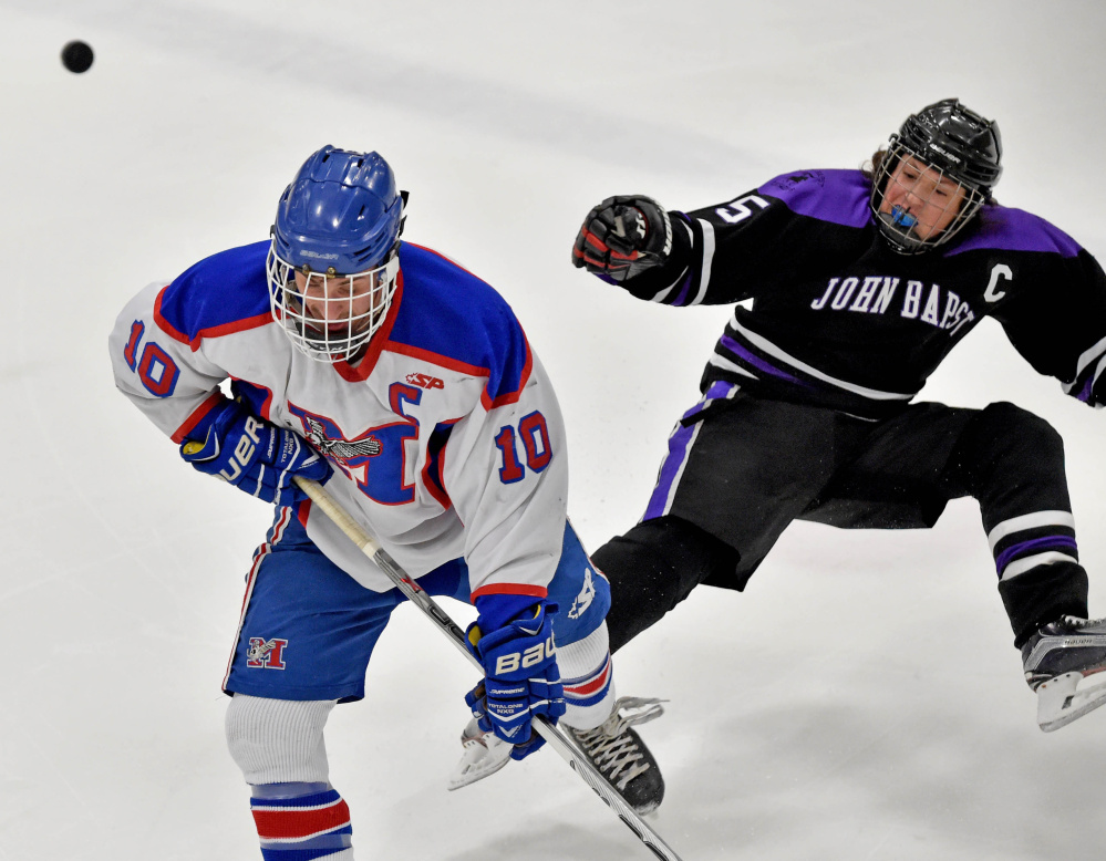 Messalonskee forward Brandon Nale gets past John Bapst’s Tyler Wheeler during the first period of a Class B North quarterfinals Tuesday at Sukee Arena in Winslow.