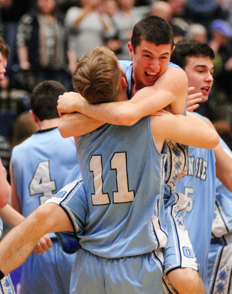 Oceanside’s Riley Sprague gets hugged by teammate Josh Luttrell as the Mariners celebrate a win over Medomak Valley in the Class A North championship game Friday at the Augusta Civic Center.