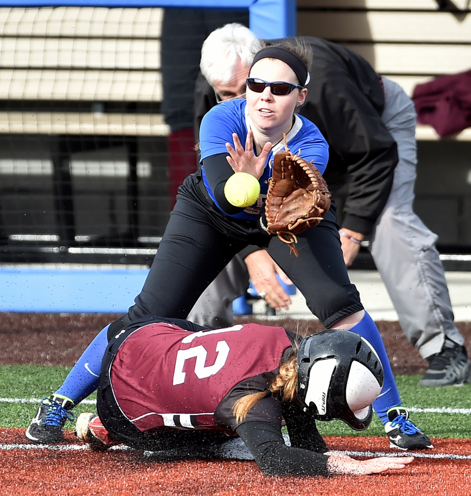 Colby College third baseman Paige Hartnett waits for the ball as University of Maine at Farmington runner Ashley Gleason slides safely into the bag during a non-conference game Wednesday in Waterville.