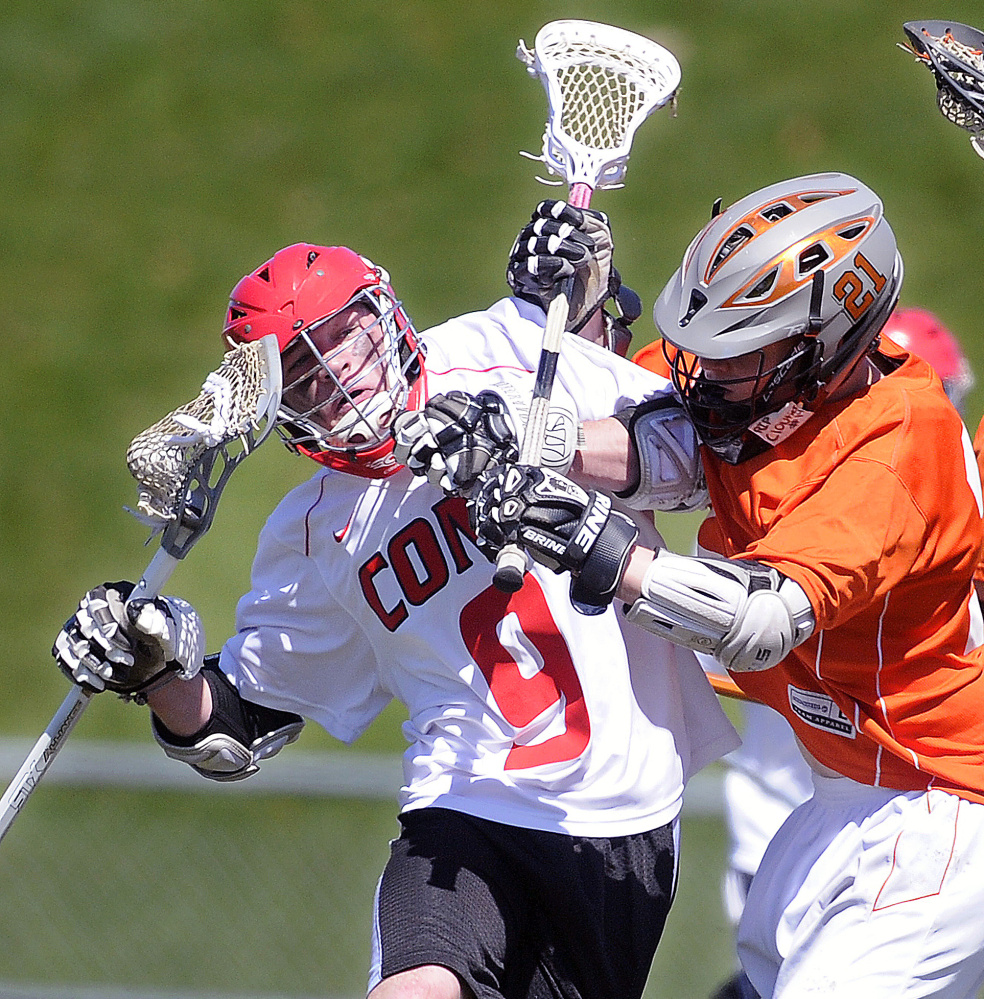 Cony High School's Bret Sprout, left, is checked by Gardiner Area High School's Sloan Berthiaume during a boys lacrosse game Thursday in Augusta.