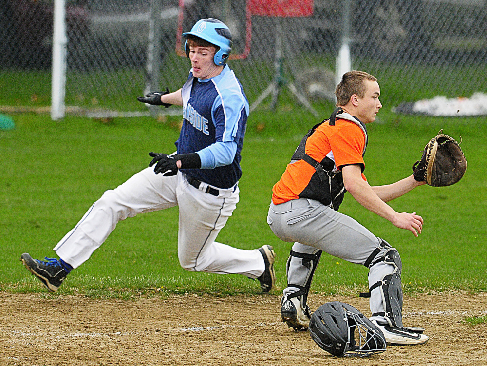 Oceanside runner Coby Dorr slides into home as Gardiner catcher Kolton Brochu waits for the throw during a game Saturday in Gardiner. Dorr scored to give Oceanside a 3-1 lead in the seventh inning.