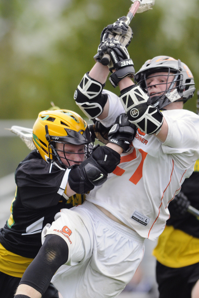 Gardiner's Sloan Berthiaume, right, scores while getting hit by Maranacook's Drew Davis during a lacrosse game Wednesday in Gardiner.