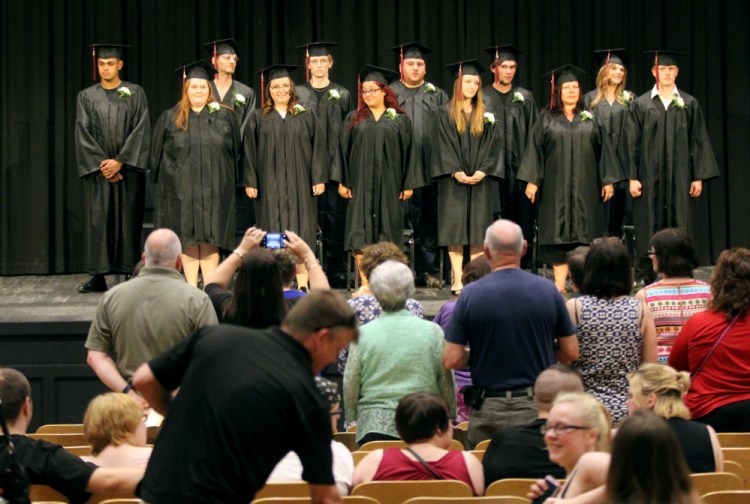 Soon-to-be graduates of Mid-Maine Regional Adult Community Education stand before family and friends at the beginning of the graduation ceremony Tuesday night at Trask Auditorium at Waterville Senior High School.