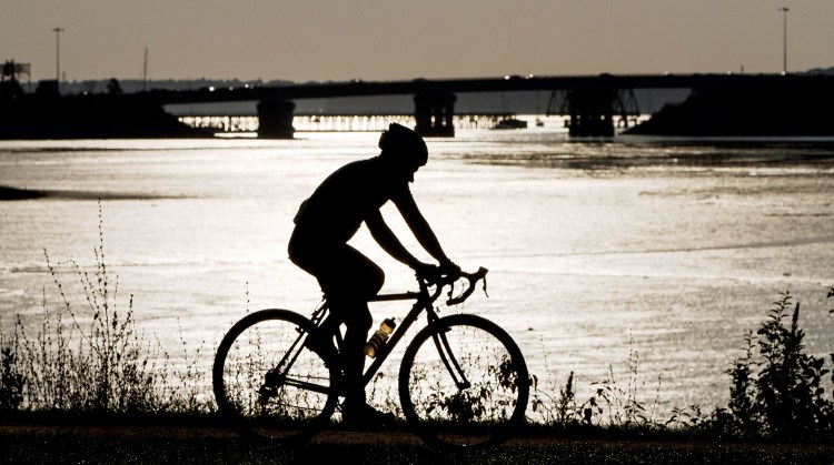 In this 2015 file photo, a cyclist speeds along the Back Cove Trail in Portland.