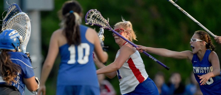 Messalonske's Lydia Dexter, middle, takes a shot on goal during the Class A North title game Wednesday night against Lewiston at Thomas College in Waterville.