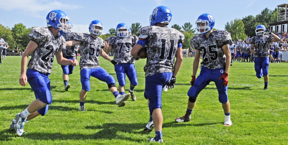 Oak Hill players run to congratulate Jonah Martin (11) after he scored a touchdown in the second quarter of game against Dirigo on Sept. 12, 2015 in Wales.