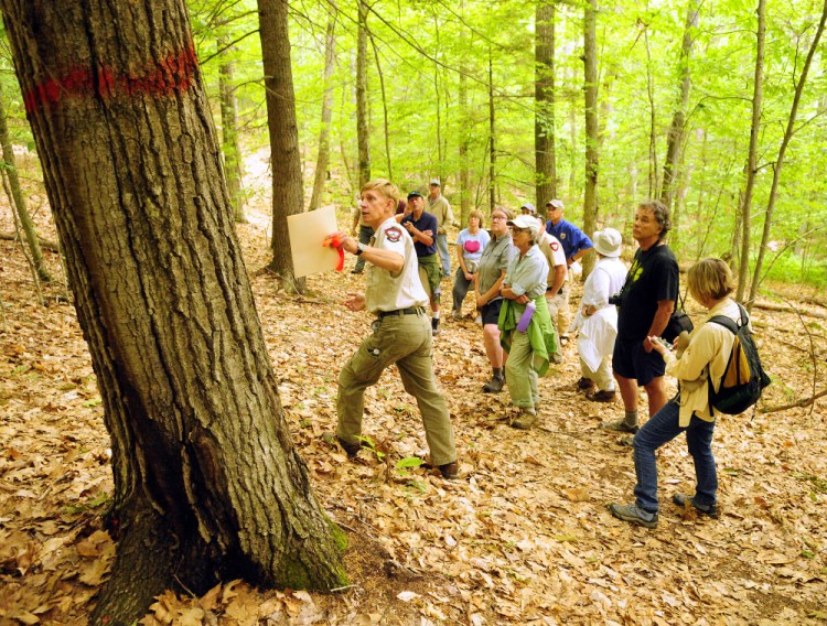 Department of Inland Fisheries and Wildlife Forester Eric Hoar, left with folder, leads a tour Tuesday of areas that will be cut at Jamies Pond Wildlife Management Area in Hallowell.