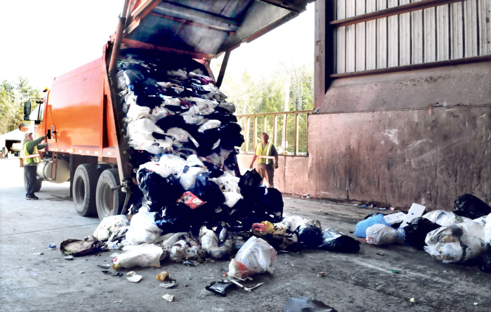 Waterville Public Works employees watch as a city garbage truck drops a load off at the Oakland transfer station in 2014. The trash from the transfer station goes to the PERC incinerator in Orrington. Waterville is looking for other options for its trash in 2018, when the PERC contract expires, but Oakland will be sending its trash to the Fiberight waste-to-energy plant in Hampden.