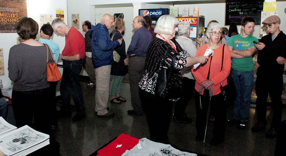 Pat Clark, center, of Unity, seen in the lobby of the Railroad Square Cinema in Waterville on Sunday, is taking part in this year's Maine International Film Festival as she has for the last 19 years. Clark believes she is the very first person to purchase a pass for all movies each year and estimates she has seen well over 600 MIFF movies.