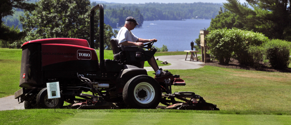 Mike Nadeau drives a rough mower at the Augusta Country Club on Wednesday in Manchester.