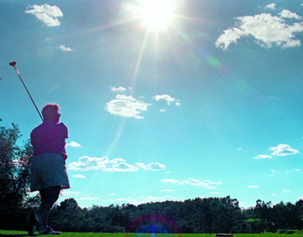 Linda Gifford tees off into the setting sun from first tee at Augusta Country Club on a warm July night in 2013.