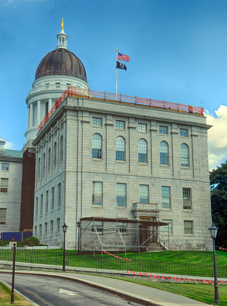 A fence rings the roof of the Senate wing of the State House on Tuesday in Augusta, where repairs are taking place.