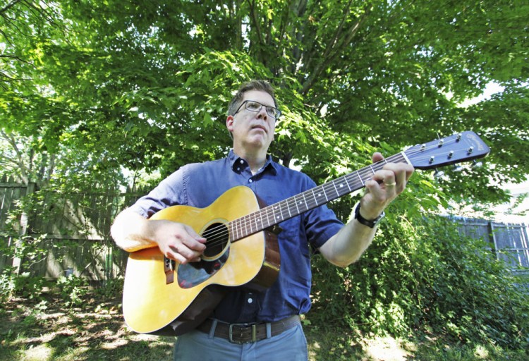 Jason Crigler plays his 1964 Martin 00-18 at home in South Berwick. (Photos by Jill Brady/Staff Photographer)