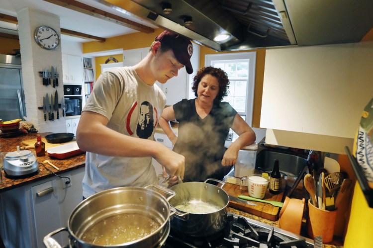 Christine Burns Rudalevige talks her son Owen through making a béchamel sauce for mac and cheese at their home in Brunswick.