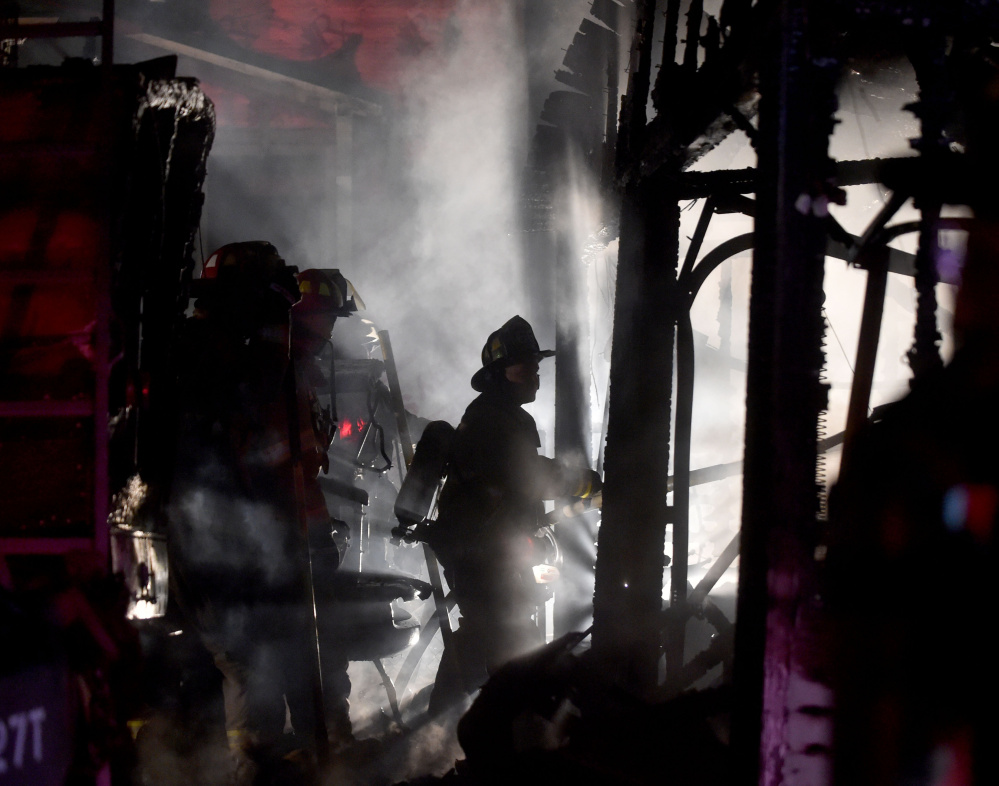 Waterville firefighters battle a Wednesday night fire that destroyed a garage, boat and pickup truck. The cause of the fire is under investigation.