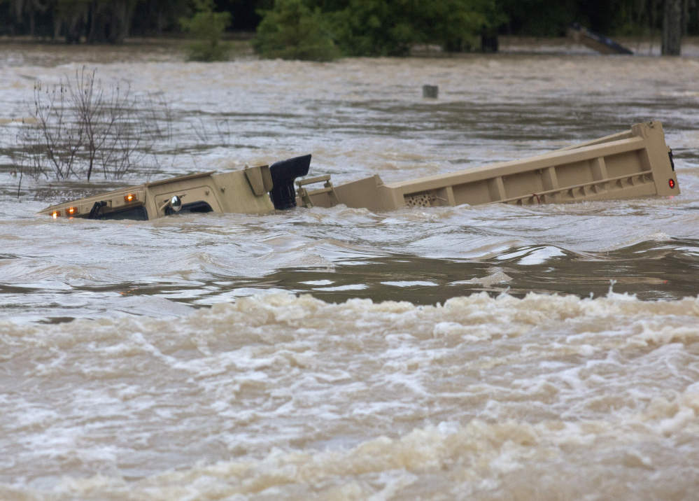 A Louisiana Army National Guard dump truck that drove off the road is submerged in floodwaters near Walker, La., on Aug. 14 after heavy rains inundated the region.