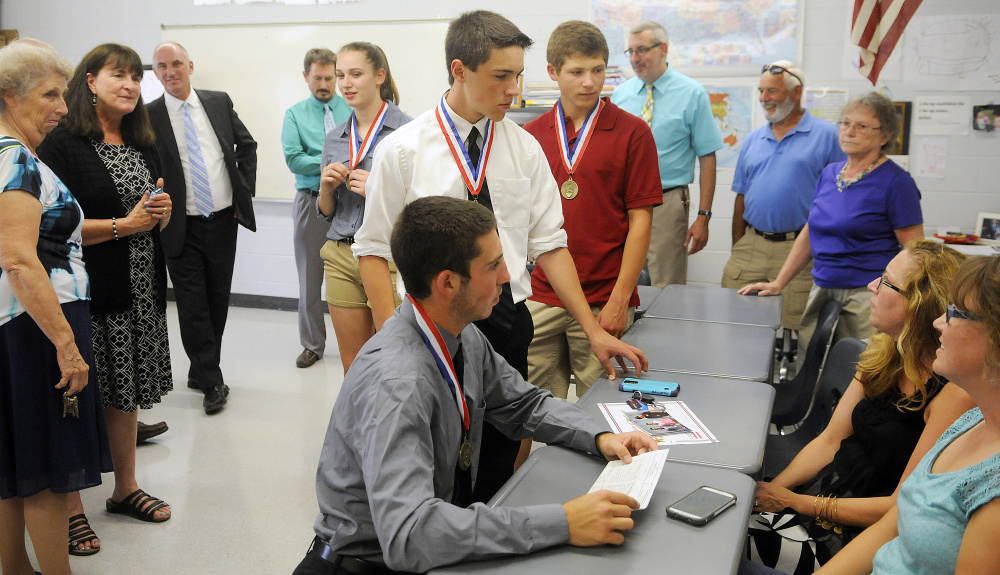 Monmouth Academy students, center, were recognized on Thursday with medals at the school for making a film that won best presentation from Maine at the National History Day Competition in Washington, D.C. The documentary explored the Acadian deportation from Canada in the 1700s.