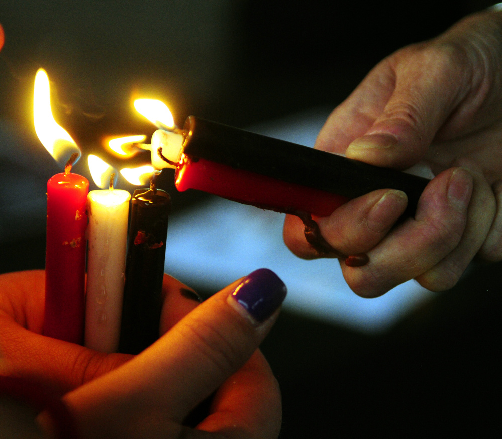 Vigil attendees light candles Saturday during The Addict's Mom Light of Hope event in Mill Park in Augusta.