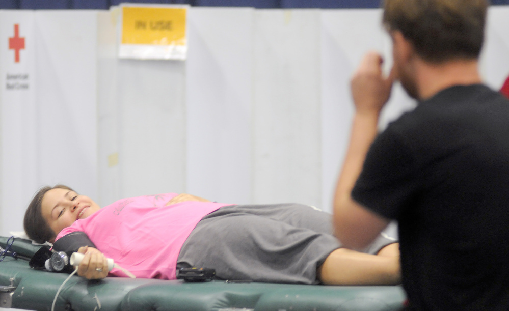 Katherine Webber smiles at her friend, Seth Cater, as they donate blood Sunday at a drive in Augusta.