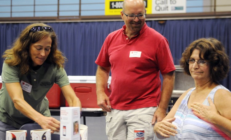 Red Cross volunteers Carol Payne, left, and Don Macomber assist blood donor Sue Baker during a drive Sunday in Augusta.