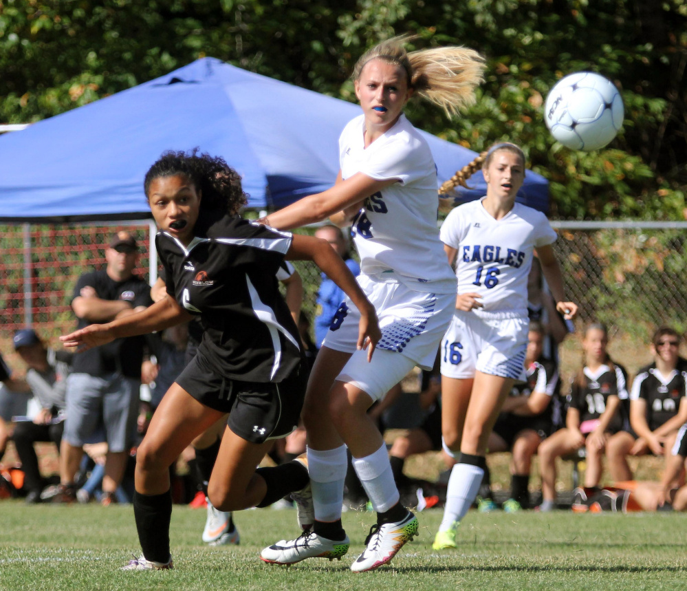 Winslow's Lidia Santos, left, and Erskine's Makayla Stevens battle for the ball during first-half action Saturday in South China.