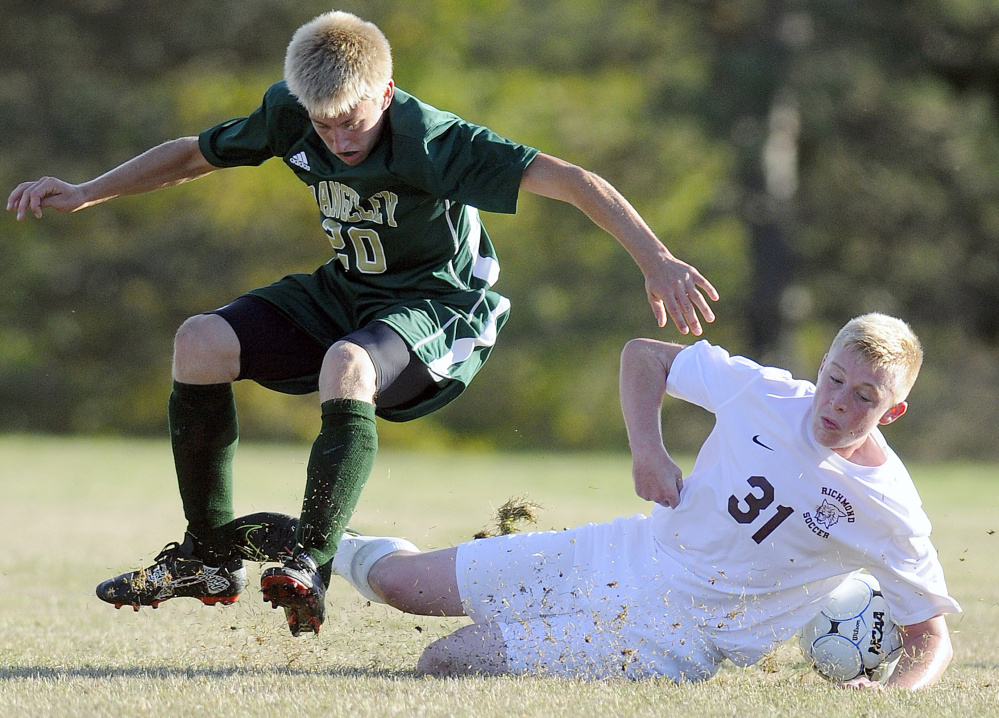 Richmond's Adam Beaulieu, right, falls down while chasing after the ball with Rangeley's Nathan Van Buren on Tuesday in Richmond.