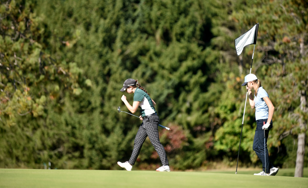 Carrabec's Katie Dixon, center, celebrates her putt on the ninth hole as Greta Freiburger, of Dirigo, holds the flag during the Mountain Valley Conference qualifier Wednesday at Natanis Golf Course in Vassalboro.