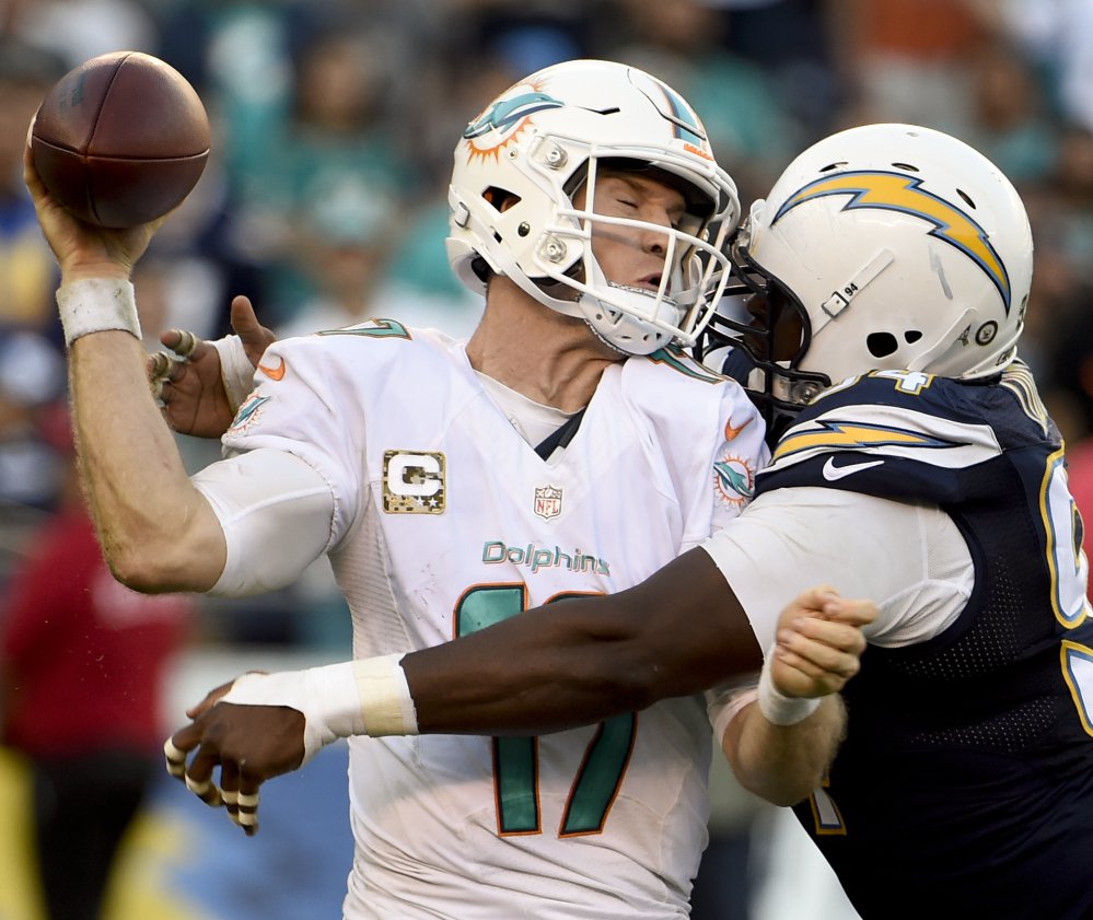 Dolphins quarterback Ryan Tannehill is hit by Chargers defensive end Corey Liuget as he tries to throw a pass Sunday in San Diego. Miami rallied for a 31-24 victory.