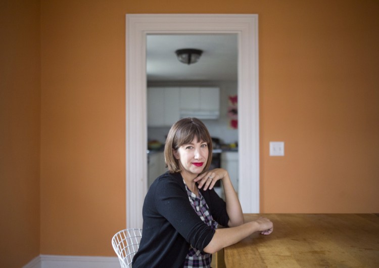 A seemingly serene Emily Butters in the dining room of her home in Brunswick. Butters and her husband, Forrest Butler, are getting ready to host their first Thanksgiving at their home this year.