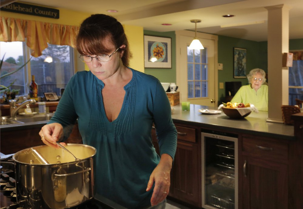 Mollie Martin spoons out cheese sauce for her grandmother, Phyllis Sanders, to taste-test. The recipe came from Sanders' husband's family.