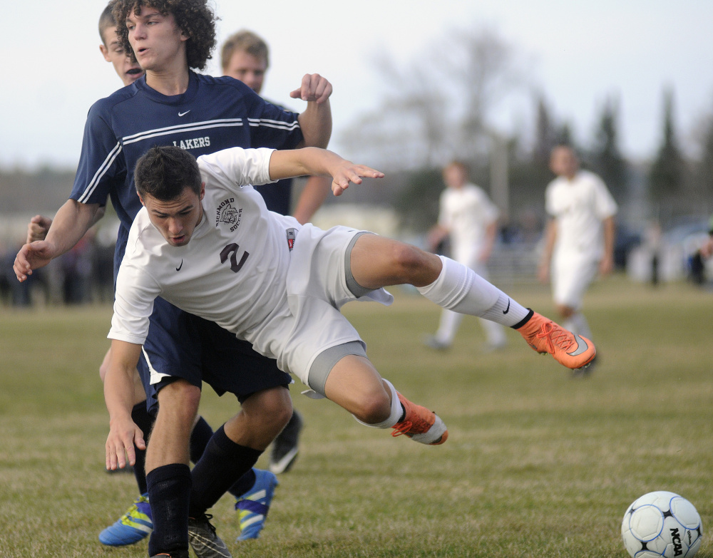 Richmond's Matt Rines (2) gets flipped by Greenville's Trajdan MacFadyen during the Class D South regional final Wednesday in Richmond.