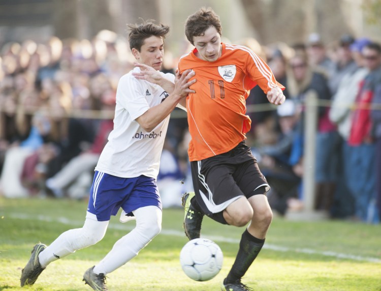 Winslow's Isaac Lambrecht is shoved by John Bapst's Brady Chadwick during a scramble to control the ball in the second half of the Class B North final Wednesday in Orono.