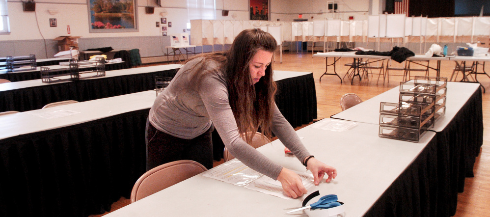 Waterville Deputy Clerk Sarah Cross tapes voting instructions to tables at the American Legion hall in Waterville on Monday, in preparation for Election Day. Voting times are from 7 a.m. to 8 p.m. in Waterville — an hour earlier than usual — for expected high turnout.