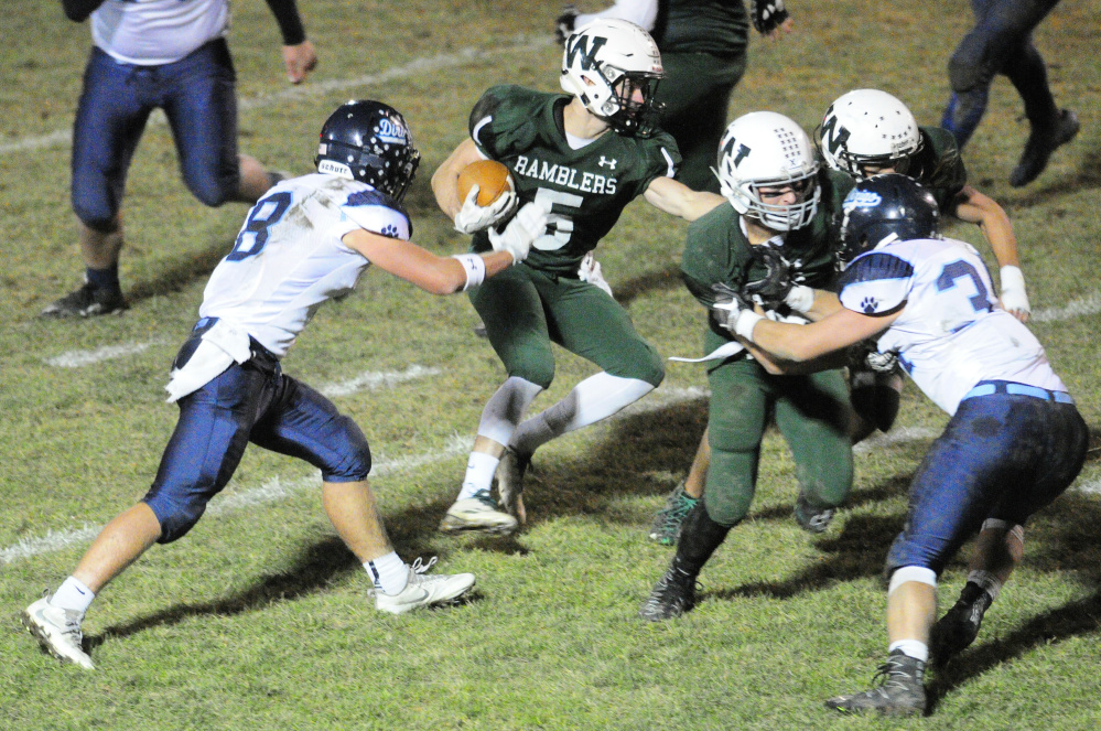 Dirigo's Cameron Turner, left, tries to tackle Winthrop's Nate Scott (5) during a Class D South semifinal Friday at Maxwell Field in Winthrop.