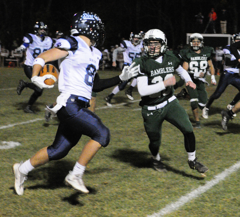 Staff photo by Joe Phelan 
 Dirigo's Cameron Turner, left, gets chased toward the sidelines by Winthrop's Antonio Meucci during a Class D South semifinal Friday at Maxwell Field in Winthrop.