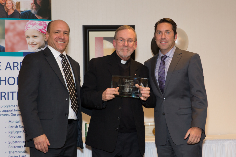 St. Michael's Parish in Augusta was recognized with the Faith-based Partner Award for its ongoing contributions to Catholic Charities programs like SEARCH, Threads of Hope Thrift Stores and Refugee & Immigration Services as well as community ministries, including the Angel Food Suppers that feed the homeless and an art program for youth in area shelters. From left are Stephen Letourneau, Catholic Charities Maine CEO; the Rev. Frank Morin, of St. Michael's Parish in Augusta, accepting the award; and David Madore, Catholic Charities Maine Board Chairman.