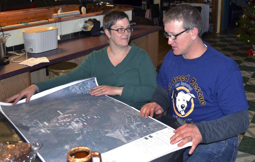 Debbie and Richard Higgins, whose well water has been contaminated by a suspected carcinogen from a Dartmouth College dump site, look at a map on their kitchen table in Hanover, N.H., which shows where the contamination has spread. Dartmouth says it has spent around $8.4 million cleaning up contamination where scientists dumped carcasses of lab animals in the 1960s and 1970s.