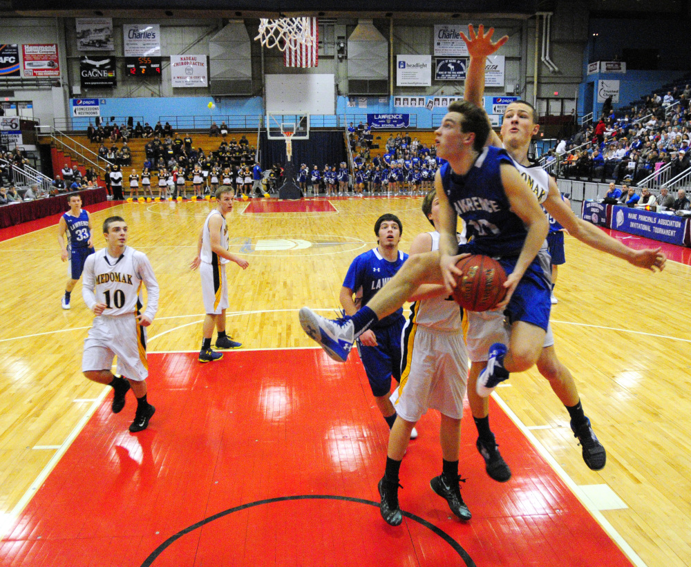 Lawrence forward Mason Cooper goes up to shoot as Medomak's Cameron Allaire closes in during a Class A North quarterfinal game last season at the Augusta Civic Center.